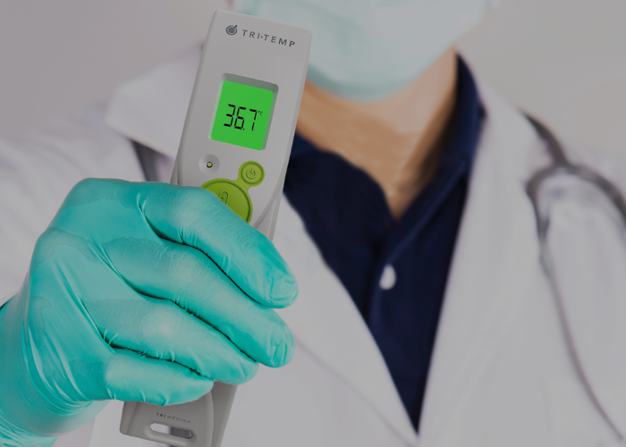 Close-up of a TriMedika non-contact thermometer taking a temperature reading without disturbing a sleeping patient, demonstrating improved comfort for remote monitoring.